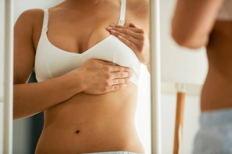 woman checking and measuring her breasts