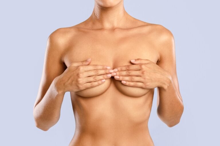 thin woman covering her breasts with hands